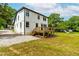 Back of home with wooden deck, grass lawn, and stone driveway at 18 W Academy St, Wendell, NC 27591