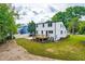View of the home's backyard with a wooden deck, stone driveway, and grass lawn at 18 W Academy St, Wendell, NC 27591