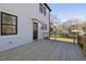 A back porch featuring natural-colored wooden planks, a black door, and a white exterior at 18 W Academy St, Wendell, NC 27591