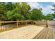 Spacious wood deck bordered by trees and a charming white fence at 18 W Academy St, Wendell, NC 27591