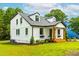 Exterior view of a two-story home with white siding, black trim, dormer windows, and a welcoming front porch at 18 W Academy St, Wendell, NC 27591