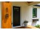 Close-up of the front door with decorative number, flower box, and a potted plant on the inviting wood porch at 18 W Academy St, Wendell, NC 27591