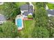 Stunning aerial view of home with a large pool, manicured lawn, firepit area and beautiful landscaping at 1817 Foxbrook Dr, Raleigh, NC 27603