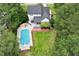 Aerial view of a home with in-ground pool, fire pit, landscaped yard, deck, and mature trees at 1817 Foxbrook Dr, Raleigh, NC 27603