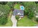 Aerial view of home with in-ground pool, mature trees, and long driveway at 1817 Foxbrook Dr, Raleigh, NC 27603