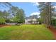 Expansive backyard with lush lawn, mature trees, and a charming patio area perfect for outdoor entertaining at 1817 Foxbrook Dr, Raleigh, NC 27603
