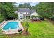 Expansive backyard with in-ground pool, screened-in porch, hot tub, patio, and lush green lawn at 1817 Foxbrook Dr, Raleigh, NC 27603