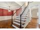 Staircase with hardwood steps, white risers, and a black banister leads to an open space at 1817 Foxbrook Dr, Raleigh, NC 27603
