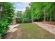 Spacious backyard with swing set, retaining wall, and mature trees at 1939 Mostyn Ln, Apex, NC 27502