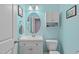 Bright bathroom with an oval mirror, white vanity, and light blue walls at 1939 Mostyn Ln, Apex, NC 27502