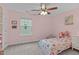 Light-filled bedroom with pink walls, a ceiling fan, and a large window at 1939 Mostyn Ln, Apex, NC 27502