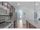 Kitchen with granite countertops and stainless steel appliances overlooks the living room at 1939 Mostyn Ln, Apex, NC 27502