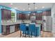 Modern kitchen with dark wood cabinets, stainless steel appliances, and a center island at 1939 Mostyn Ln, Apex, NC 27502