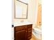 Bathroom with dark wood vanity, sink, mirror, toilet and tiled shower with tub at 1950 Menet St, Apex, NC 27502