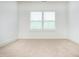 Bright bedroom with neutral carpet and white trim under a large window at 1950 Menet St, Apex, NC 27502