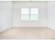 Carpeted room featuring white trim and bright, natural light from two windows at 1950 Menet St, Apex, NC 27502
