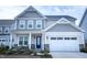 Charming two-story home featuring a two-car garage and inviting front porch seating area at 1950 Menet St, Apex, NC 27502