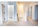 Hallway featuring white trim, carpeted floors, and doorway leading to the laundry room at 1950 Menet St, Apex, NC 27502