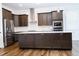 Spacious kitchen boasts dark cabinets, stainless steel appliances, and an island with seating at 1950 Menet St, Apex, NC 27502