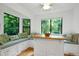 Bright breakfast nook with custom bench seating, storage, and a beautiful view of lush greenery at 2004 Flagstone Pl, Raleigh, NC 27612