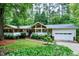Charming single-story home with lush landscaping, bright white exterior, and attached two-car garage at 2004 Flagstone Pl, Raleigh, NC 27612