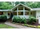 Inviting front entrance with a brick walkway and garden, leading to a modern home with large windows at 2004 Flagstone Pl, Raleigh, NC 27612
