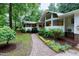 Inviting front entrance with a brick walkway and garden, leading to a modern home with large windows at 2004 Flagstone Pl, Raleigh, NC 27612