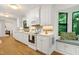Well-lit kitchen featuring white cabinetry, modern appliances, and a cozy window seat with a backyard view at 2004 Flagstone Pl, Raleigh, NC 27612