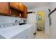Functional laundry room with wood cabinets, modern washer and dryer, and adjacent half bath at 2004 Flagstone Pl, Raleigh, NC 27612