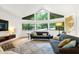 Bright living room featuring vaulted ceilings, large windows, hardwood floors, and modern furnishings at 2004 Flagstone Pl, Raleigh, NC 27612