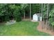Aerial view of the backyard featuring a shed, firepit, lawn and wooded area at 201 Margaret Mann Way, Pittsboro, NC 27312