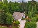 Aerial view of home nestled among mature trees, features a well manicured lawn and a basketball court at 201 Margaret Mann Way, Pittsboro, NC 27312