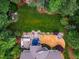 Aerial view of a backyard with manicured lawn, patio area, built-in grill, and firepit at 201 Margaret Mann Way, Pittsboro, NC 27312