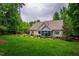 Large backyard with a screened porch, outdoor seating, manicured lawn, and mature trees at 201 Margaret Mann Way, Pittsboro, NC 27312