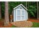 Charming backyard shed with decorative details and ample storage space, nestled among trees at 201 Margaret Mann Way, Pittsboro, NC 27312