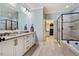 Modern bathroom with double vanity, frameless shower, soaking tub and walk-in closet at 201 Margaret Mann Way, Pittsboro, NC 27312