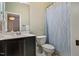 Bathroom with a single sink vanity, toilet, and bathtub with a blue and white shower curtain at 201 Margaret Mann Way, Pittsboro, NC 27312