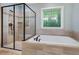 Bright bathroom with frameless shower, soaking tub, and decorative window at 201 Margaret Mann Way, Pittsboro, NC 27312