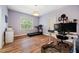 Bedroom featuring a treadmill, desk, and hardwood floors, illuminated by a modern light fixture at 201 Margaret Mann Way, Pittsboro, NC 27312