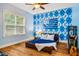 Blue bedroom with wood floors, ceiling fan, and accent wall at 201 Margaret Mann Way, Pittsboro, NC 27312