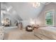 Angled-ceiling bedroom with a twin-size bed, work space and gray carpeting at 201 Margaret Mann Way, Pittsboro, NC 27312