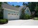 Attached two car garage with white doors and an adjacent basketball court at 201 Margaret Mann Way, Pittsboro, NC 27312