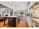 Bright kitchen features a central island with granite counters, stainless steel appliances, and hardwood floors at 201 Margaret Mann Way, Pittsboro, NC 27312