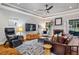 Bright living room featuring a ceiling fan, a fireplace and comfortable seating at 201 Margaret Mann Way, Pittsboro, NC 27312