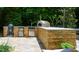 A stone patio features an outdoor kitchen with a pizza oven and built-in grill at 201 Margaret Mann Way, Pittsboro, NC 27312