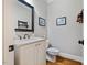 Updated powder room with elegant vanity, marble countertop, and decorative mirror at 201 Margaret Mann Way, Pittsboro, NC 27312