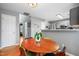 A dining area featuring a round wooden table with seating and views into the updated kitchen at 202 Stonecreek Dr, Apex, NC 27539