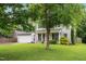Charming two-story home with a well-manicured lawn, attached garage, and inviting yellow front door at 202 Stonecreek Dr, Apex, NC 27539