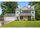 Charming two-story home with a well-manicured lawn, attached garage, and inviting yellow front door at 202 Stonecreek Dr, Apex, NC 27539