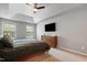 Spacious primary bedroom with a tray ceiling, ceiling fan and large windows at 202 Stonecreek Dr, Apex, NC 27539
